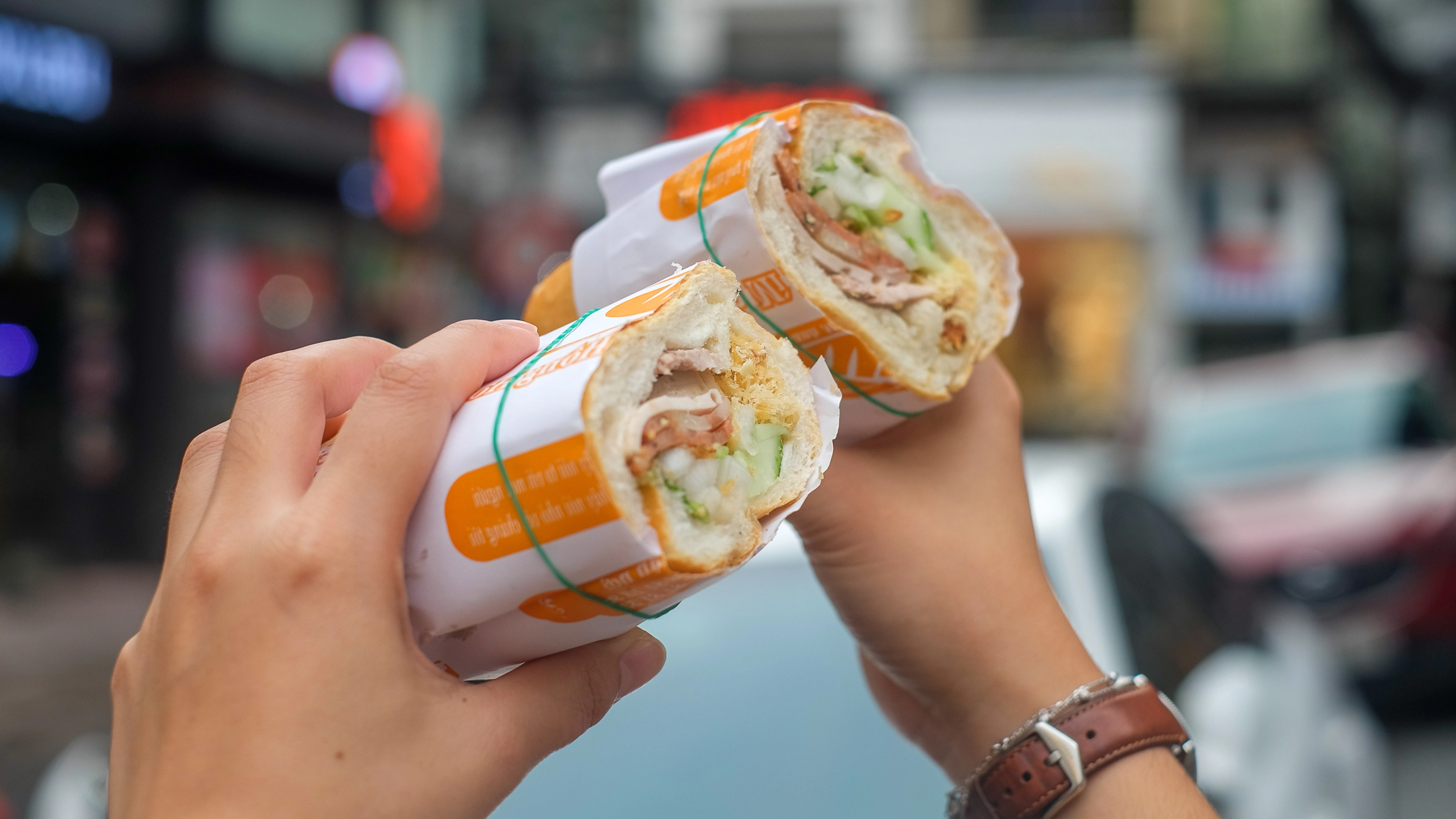 Hanoi erwacht: Eine Frau mit einem Banh Mi, einem vietnamesischen Sandwich