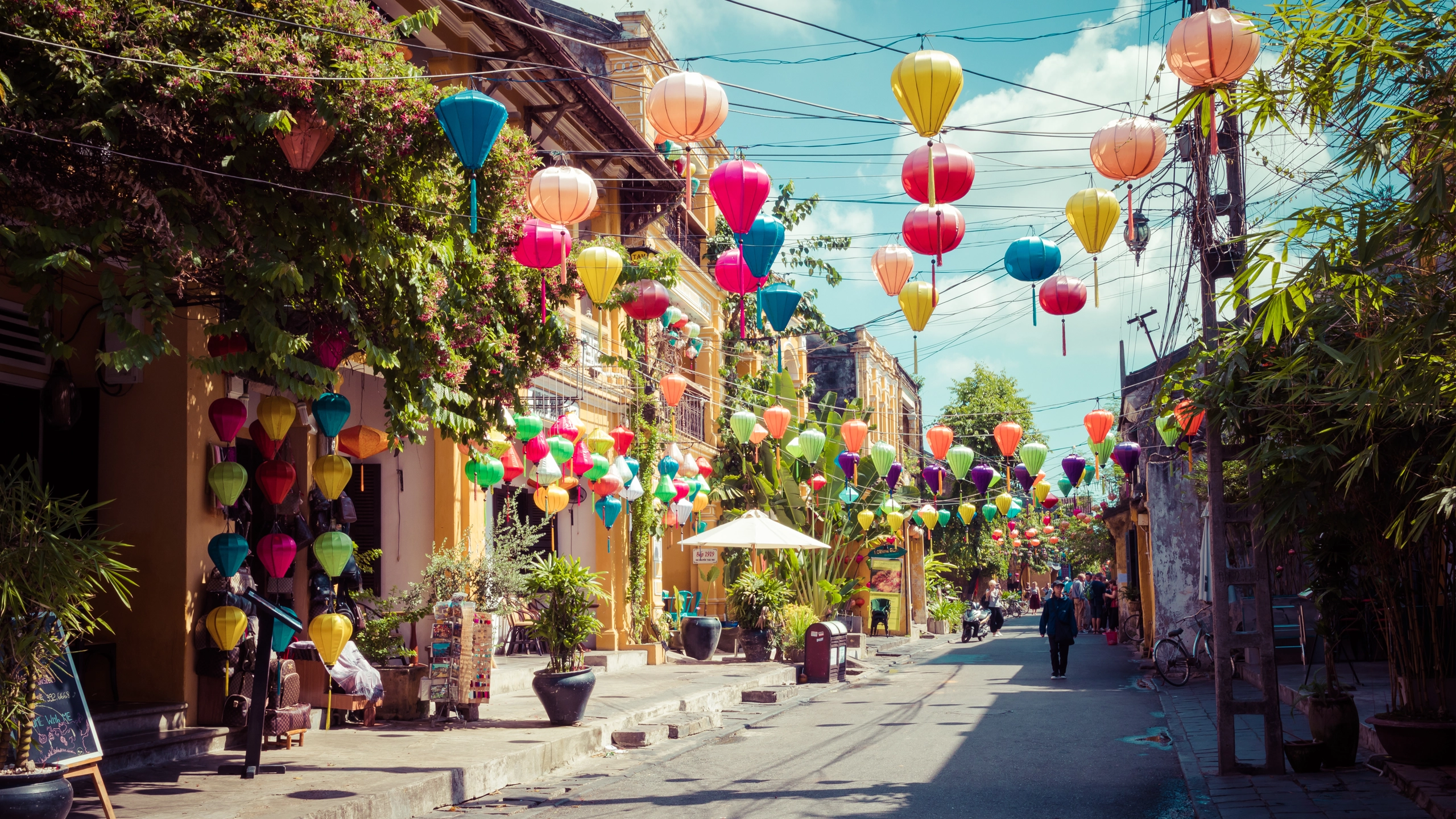 Hanoi erwacht: Frau schiebt ein Fahrrad beladen mit Köstlichkeiten